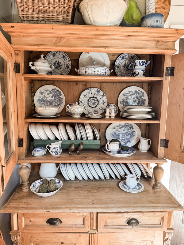 Vintage Blue and White Decorations on Shelves in kitchen cabinet for farmhouse decorating.