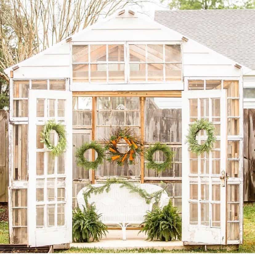 Reclaimed windows are used in this dream greenhouse ideas decorated seasonally for she shed ideas.