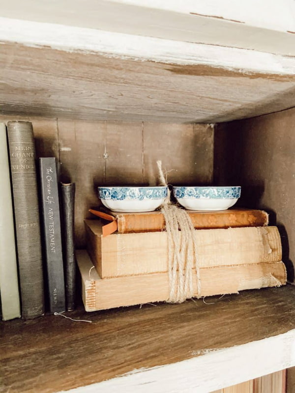 Add old books for decorations on shelves in antique cabinet.  