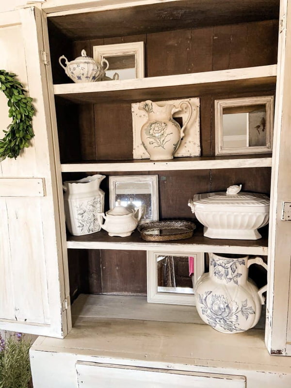 Shelf Styling with Vintage mirrors at the back of the antique cabinet.