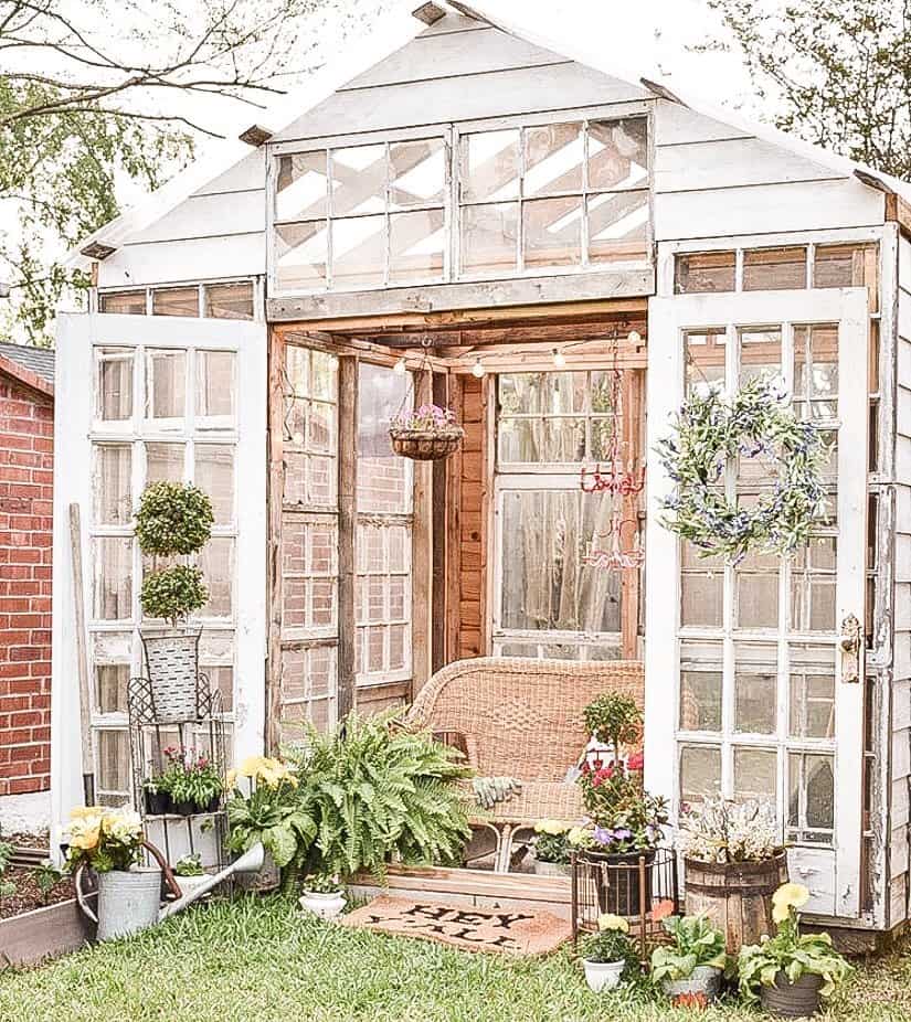 Reclaimed windows are used in this dream greenhouse ideas decorated seasonally for she shed ideas.