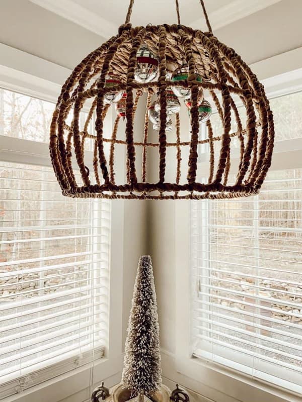 Basket light fixture with Vintage Christmas ornaments hanging in the center.