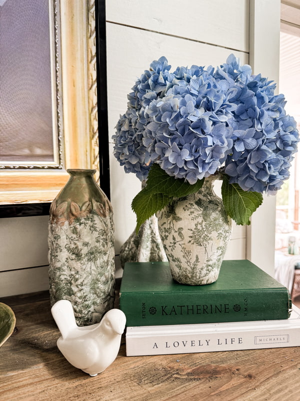 blue hydrangeas in upcycled thrift store vases on DIY Fireplace Mantel.  