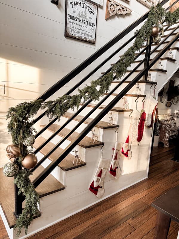 Cedar Garland with napkin decoupage and gold Christmas ornaments on staircase banister.