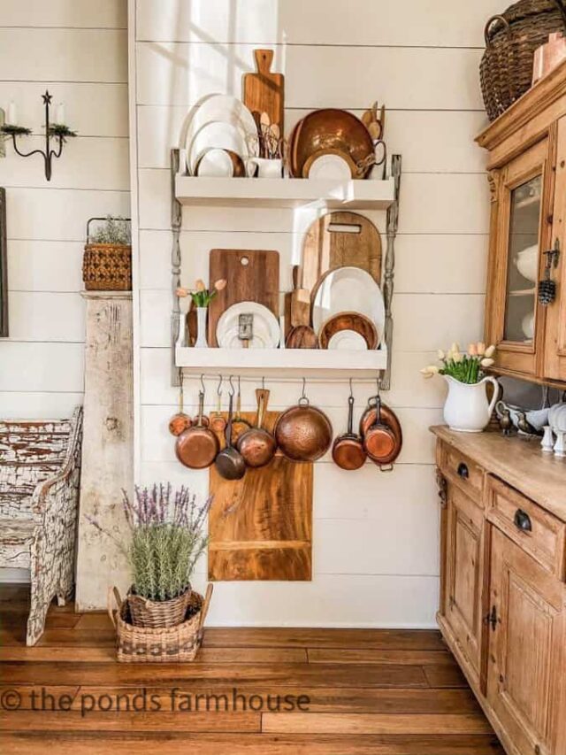 Farmhouse kitchen view with copper pots, breadboards, and Ironware dishes.