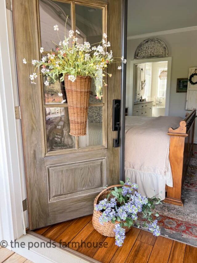 wall basket with faux flowers on bedroom door.