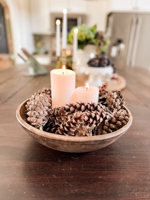 https://www.thepondsfarmhouse.com/wp-content/uploads/2023/08/Foraged-Pinecones-in-wooden-bowl-with-candles-for-cozy-fall-decorating.jpg