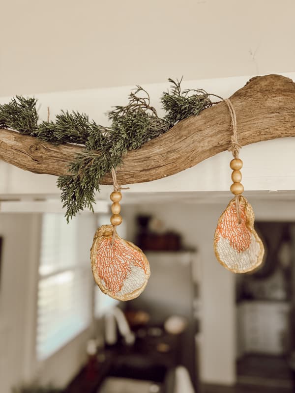 Oyster Shell Napkin Decoupage Christmas ornaments on driftwood branch.