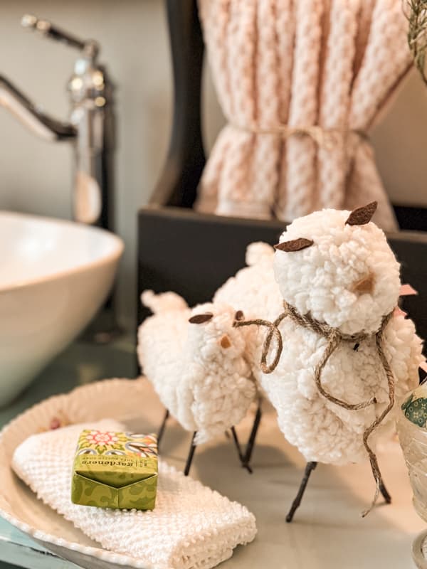 Recycled lambs on a bathroom tray with soaps and bath clothes. 