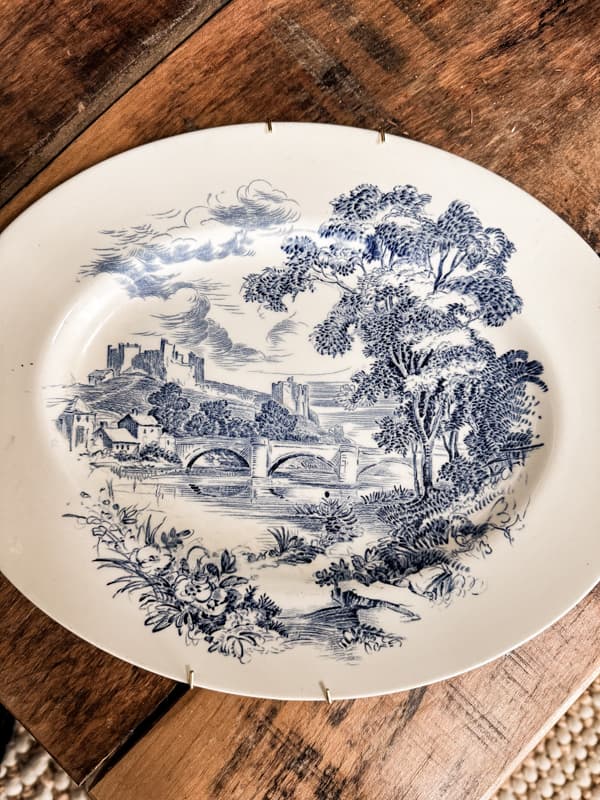 Decorating plates on wall with vintage thrift store dishes and antique finds.Blue and White plates to create unique plate wall display