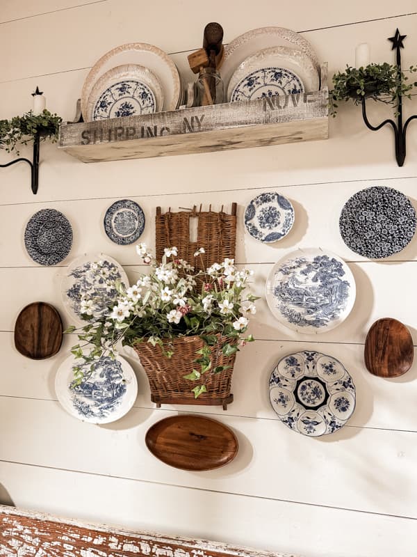 Decorate dining room wall with wall hanging plates and vintage basket beside the farmhouse table. 
