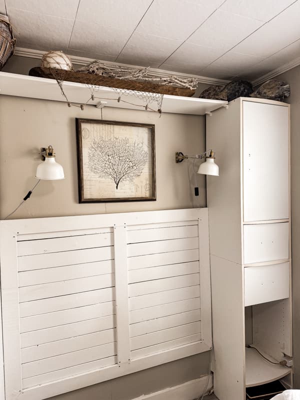 Old built-in cabinets surrounding bed in tiny beach cottage.