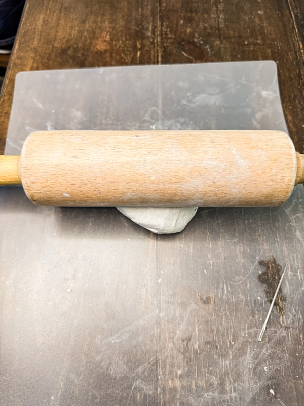 roll clay flat with rolling pin.