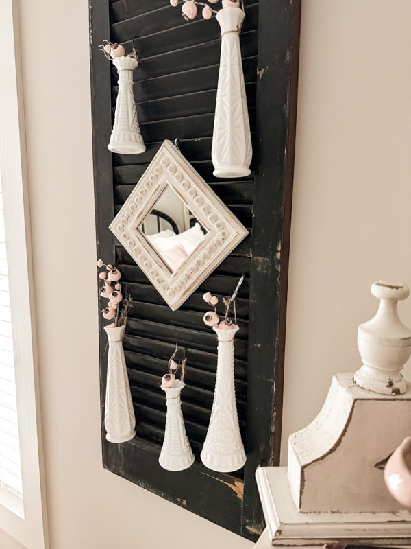 Beaded idea by adding a thrift store mirror to a shutter with vintage milk glass bud vases. 