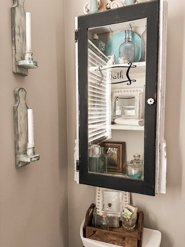 Beaded mirrors are tucked into a tray and inside the bathroom wall cabinet.