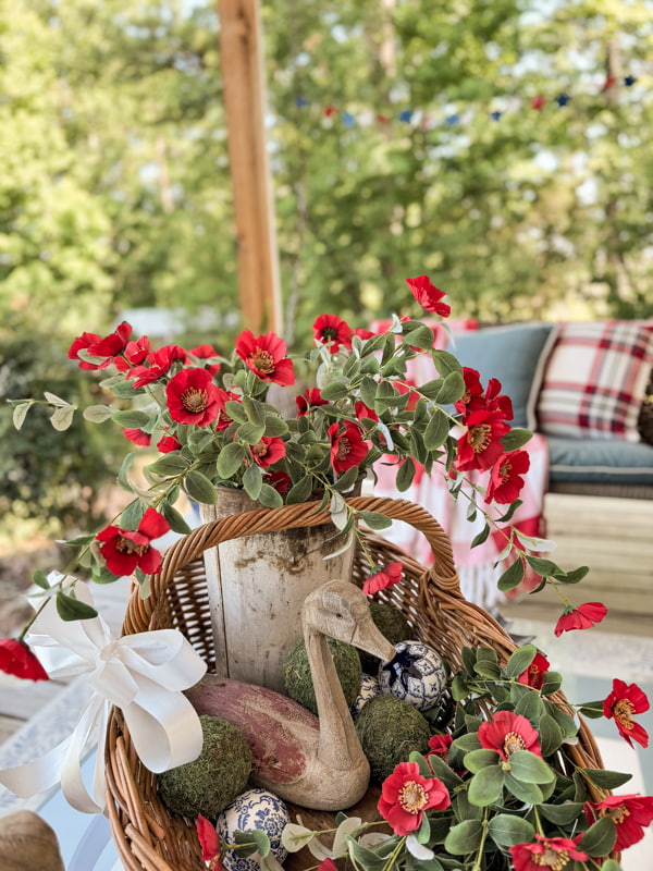 Red, white and blue decorations for patriotic front porch with red anemones and rustic basket 