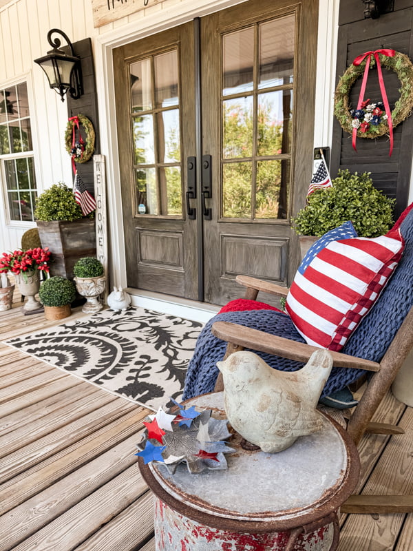 French doors with rockers and pinecone flower patriotic wreaths and flags