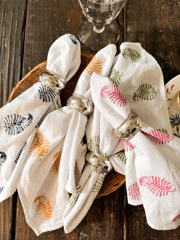 DIY Block Print Napkins with silver napkin rings on woven tray.  