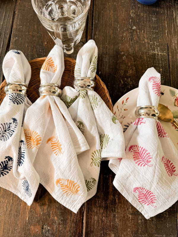 DIY Fabric Block Print Napkins in blue, yellow, green and pink with sterling silver napkin rings.  