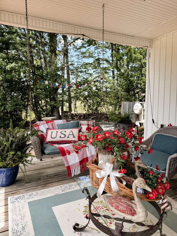 Summer porch decorations with rustic coffee table decorations and patriotic porch swing decor.  