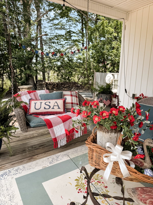 USA pillow and red and white throw blankets on swing for red white and blue patriotic decorations.  