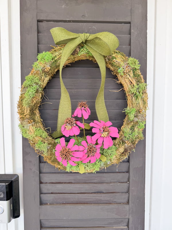 Purple cornflower summertime wreath idea made with foraged pinecone scales and gumballs on front porch. 