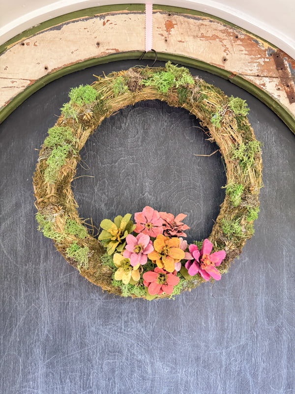 Adding DIY Zinnia Painted pinecone flowers to moss wreath for Summertime Wreath Ideas.  