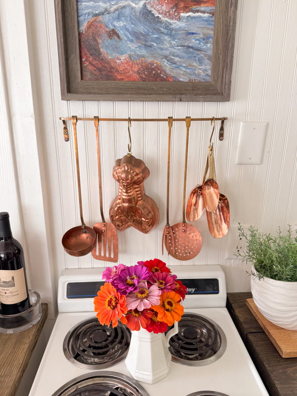Dirt Road Adventures: Zinnias in ironstone pitcher with copper kitchen utensils at beach cottage.  