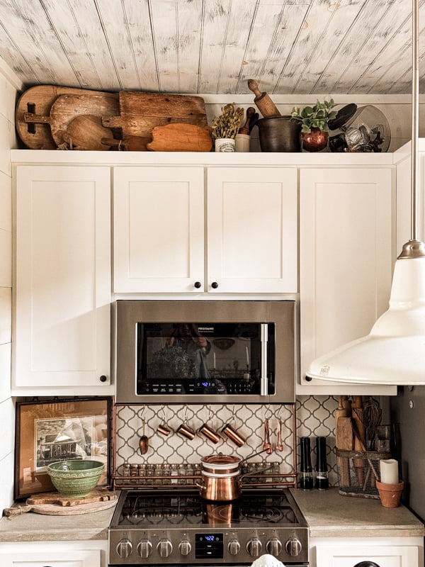 Antique Cutting boards and breadboards above kitchen cabinets for rustic farmhouse style decorating.  