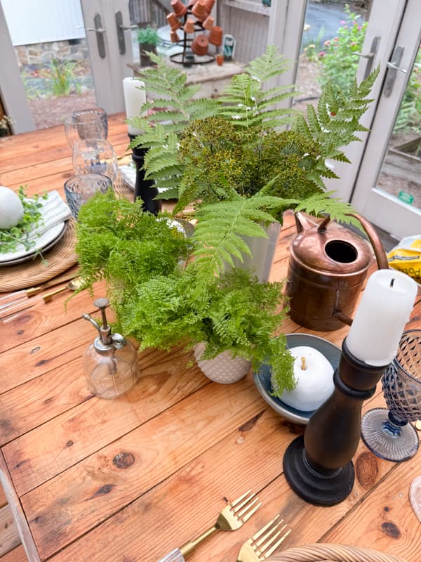 White milk glass vases with wild fern and dill arrangement and lacey ferns for centerpiece.