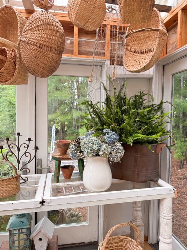 Potting Table with copper boiler filled with a fern and ironstone vase with dried hydrangeas.  