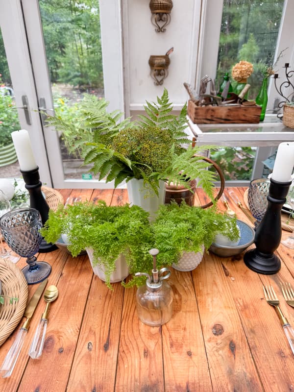 White milk glass vases with wild fern and dill arrangement and lacey ferns for centerpiece.