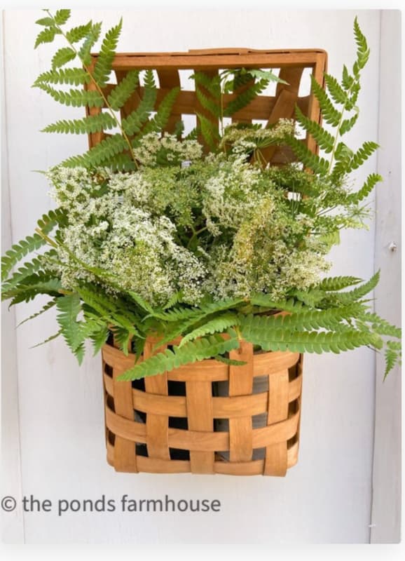 Tobacco basket filled with wildflower arrangement.  Queen Anne's Lace and wild ferns arrangement.