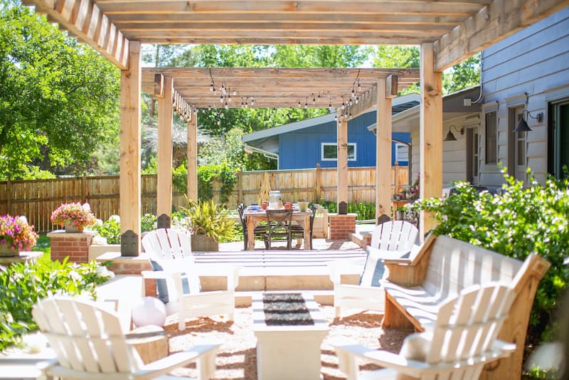 Outdoor living space with pea gravel patio and sturdy wooden pergola.  