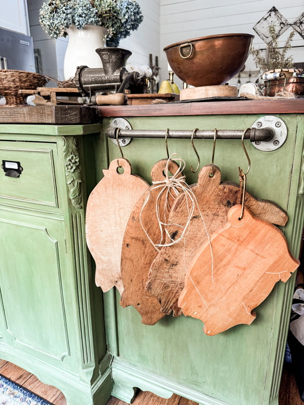 Vintage Pig Cutting Boards hanging on rail of the DIY Kitchen Island.  Thrifted and vintage finds. 