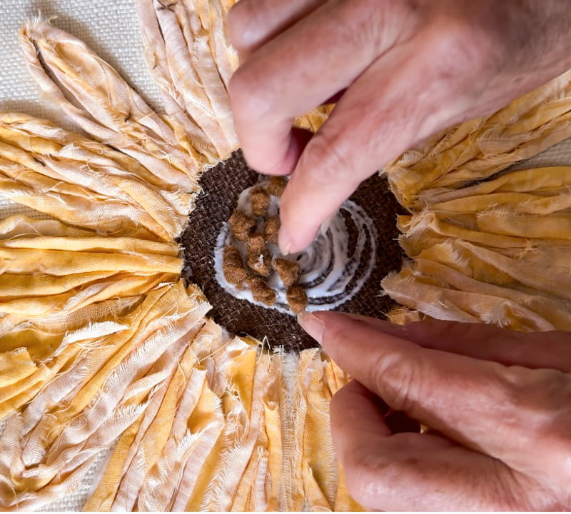 Add felt knots to the center of the flower with glue.