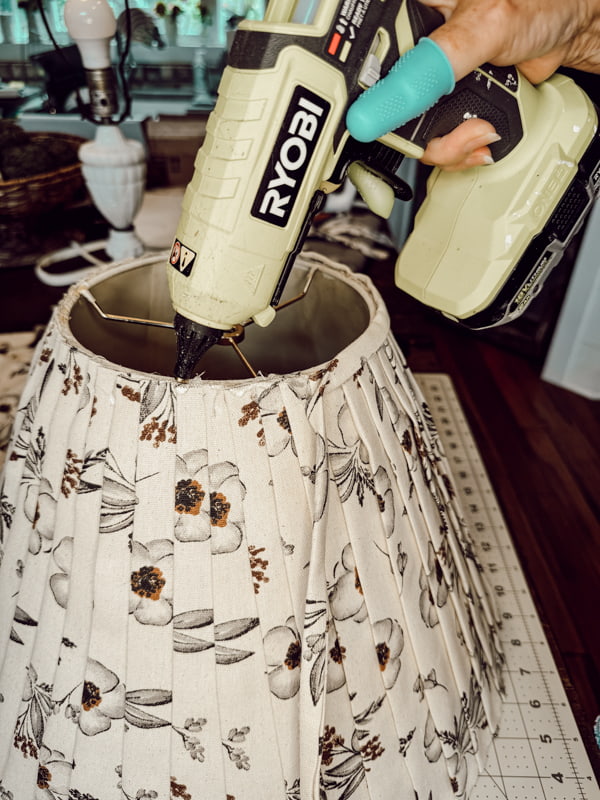 Add trim fabric for the Lampshade Makeover DIY project with pleated fabric in tan and brown.  