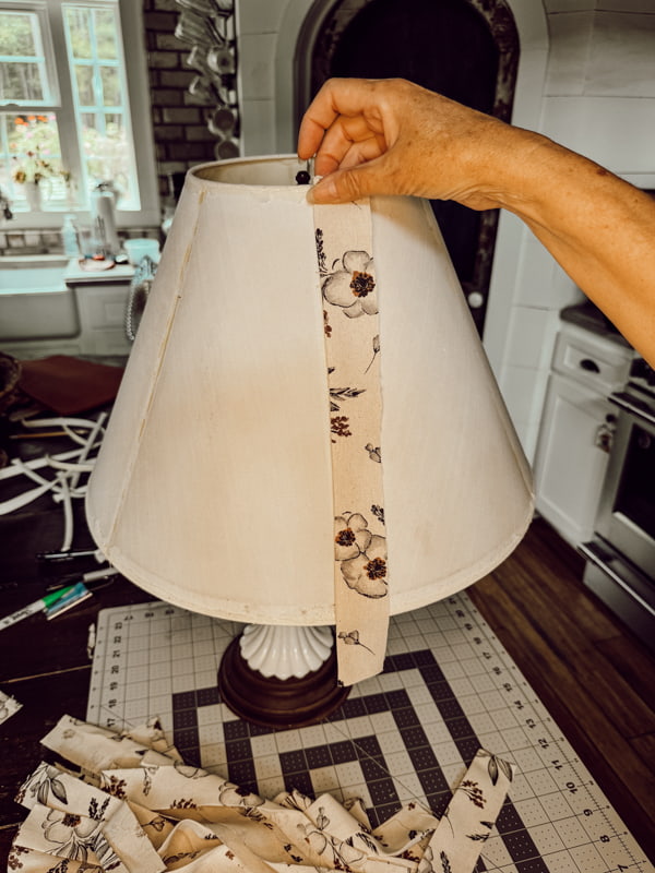 Add strips of fabric to upcycle a lampshade from the thrift store.