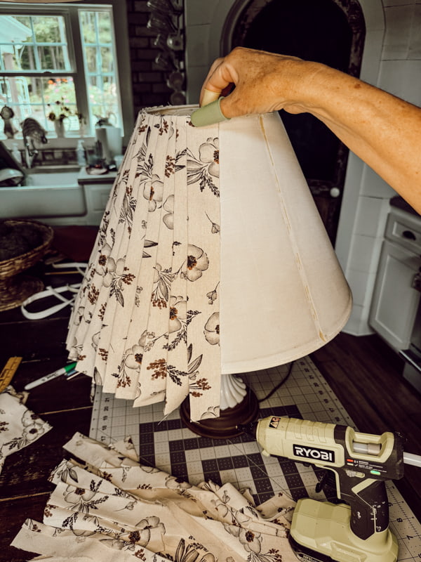 Attach fabric strips to the thrift store lampshade with hot glue