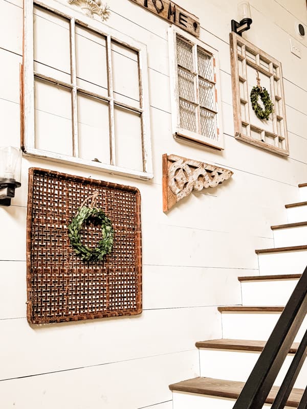 Flat square wall basket with preserved boxwood wreath with gallery wall and old windows.