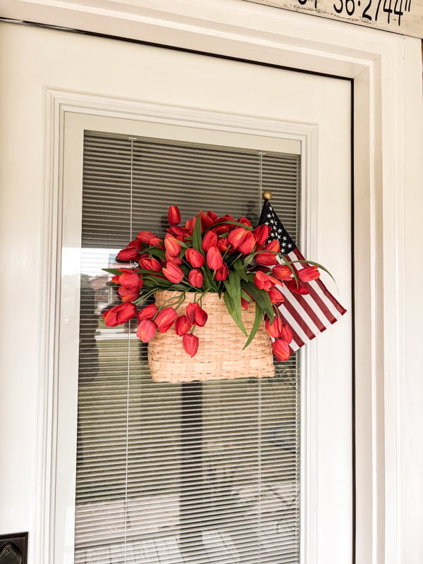 Wall basket filled with tulips and a flag for a patriotic porch wreath.