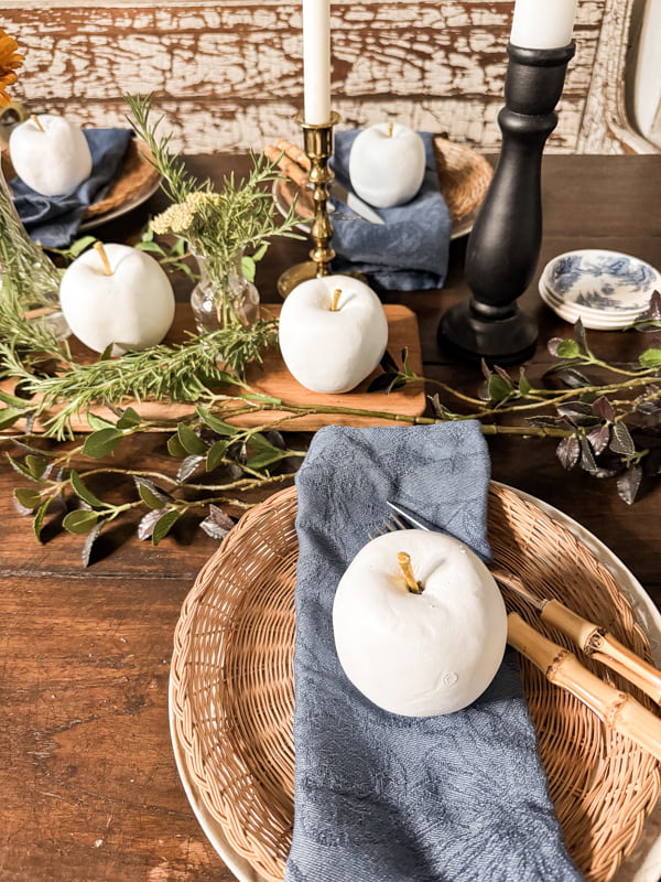 White Apple Decor on dinner plate with wicker plates and bamboo cutlery