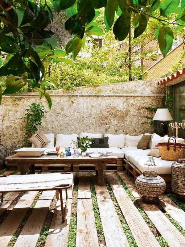 Rustic outdoor living space with pallet sectional and pallet wood over grass to create a outdoor living space ideas on budget.