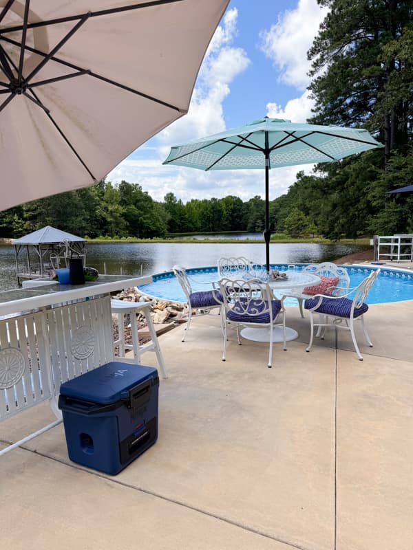 Outdoor living space ideas on a budget with secondhand dining table set and repainted bar. 