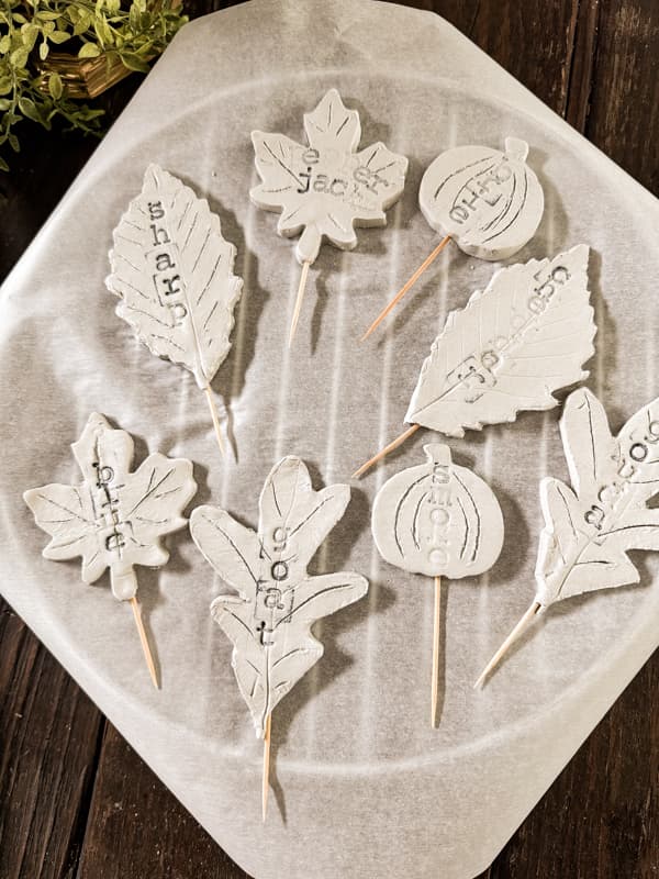 Air Dry Clay Cheese Markers drying on parchment paper on a wire rack.  