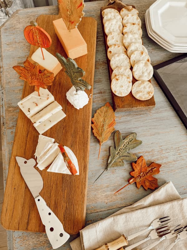 Handmade cheese markers in the shape of fall leaves and pumpkins on cheese board with crackers.Inspired by Anthropologie's Foliage Cheese Markers