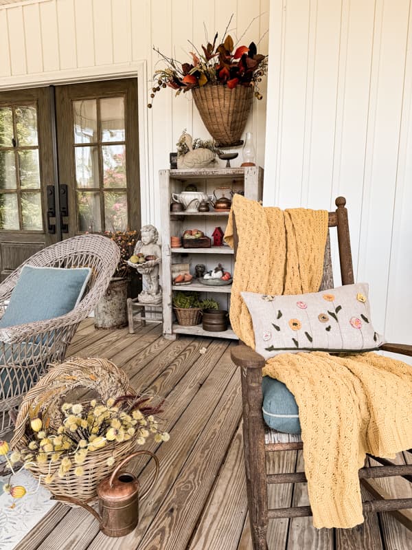 Rocking chairs and DIY scrap fabric pillow with yellow throw blanket on Fall Front Porch.