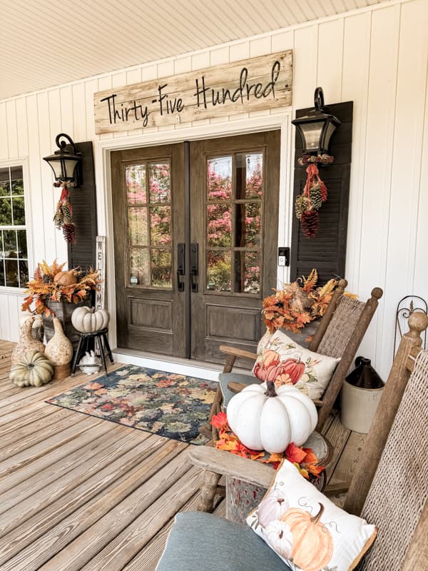 Fall Front Porch tour with hanging pinecones, pumpkins and fall rug.