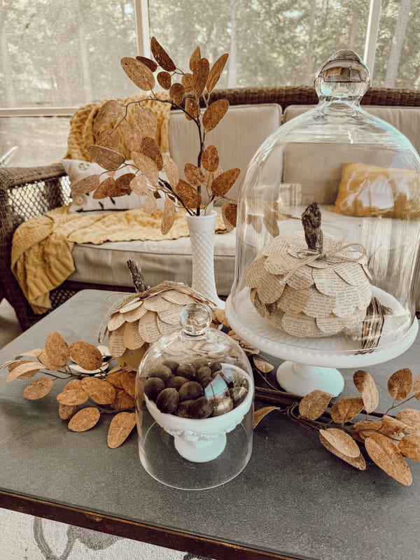 Fall coffee table milk glass centerpiece with glass cloches and DIY old book page Dollar Tree Pumpkins 