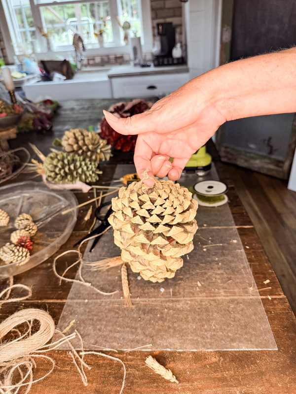 Make a hanger out of jute twine attached to the large end of the cone.